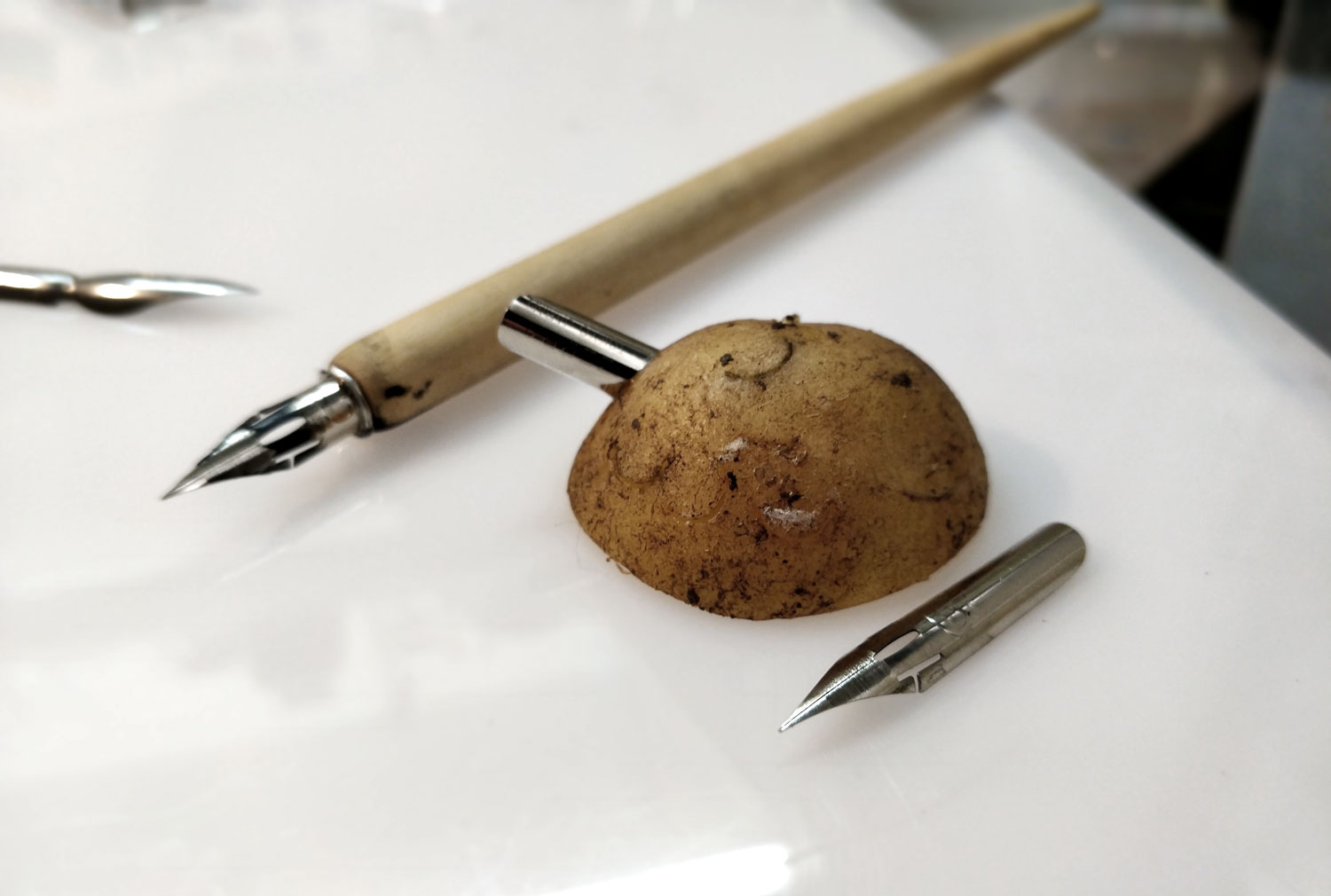 Comic book pen nib mounted in a potato, yes, that's weird.